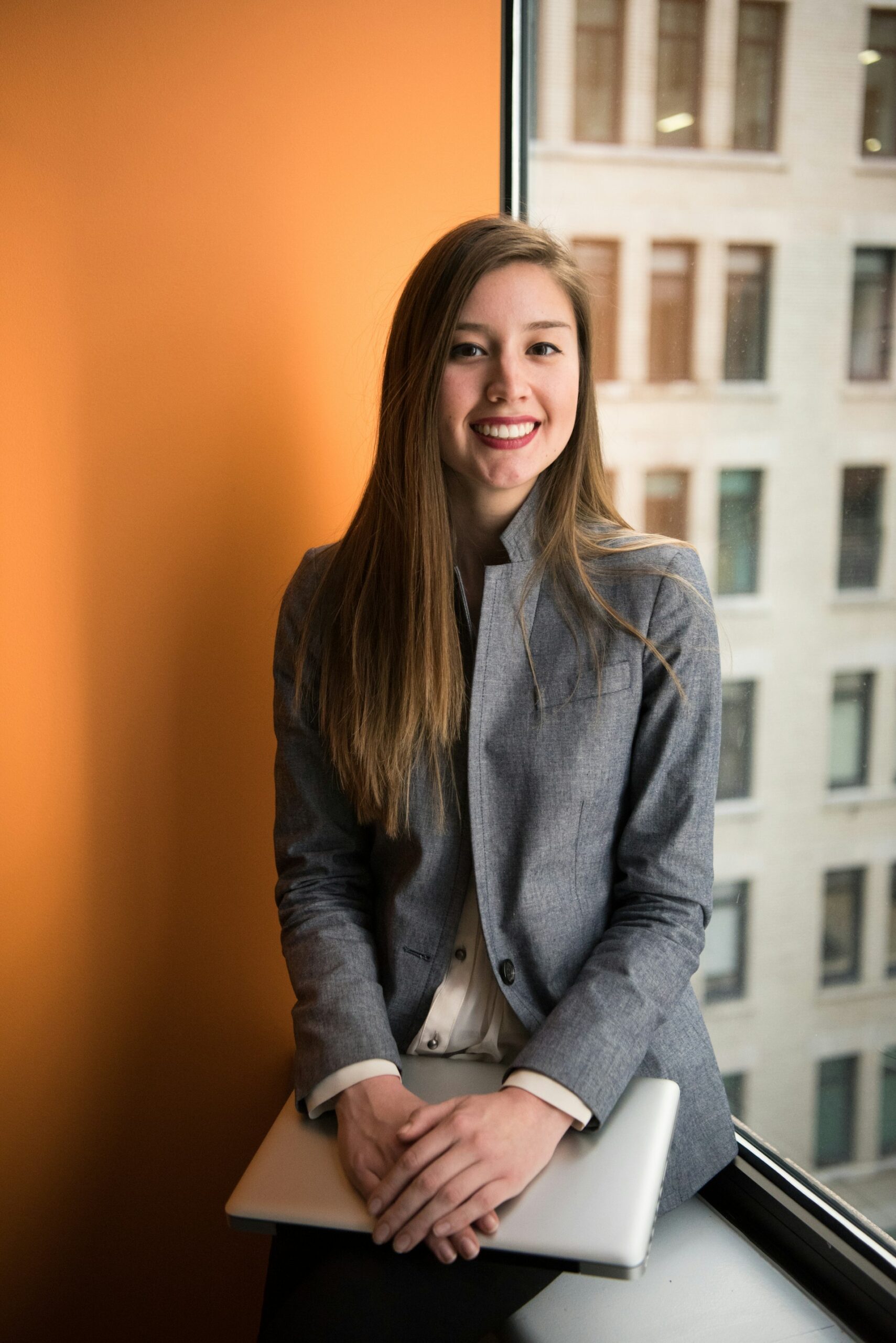 Businesswoman sitting on a windowsill in an office building